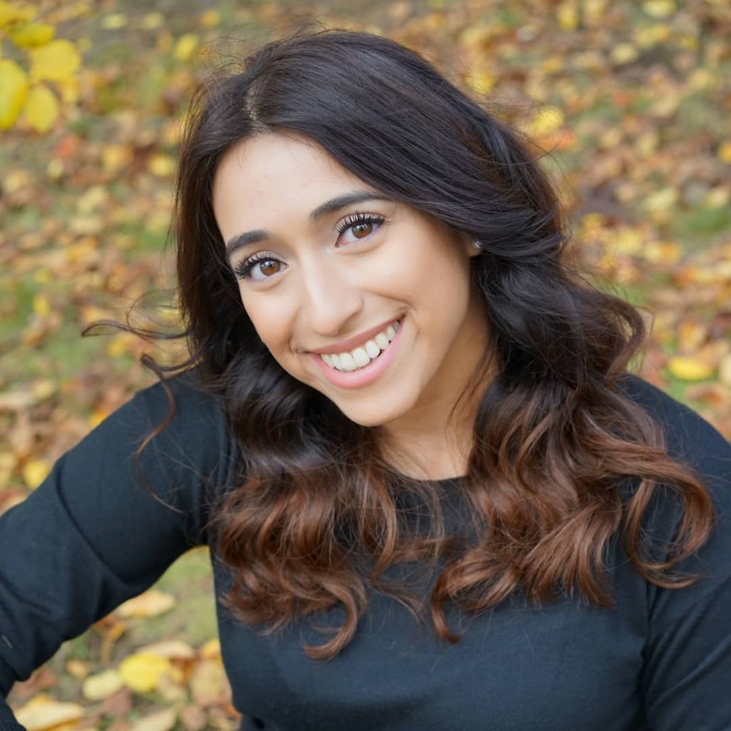 Vanity Kumar headshot with a yard of leaves in the background